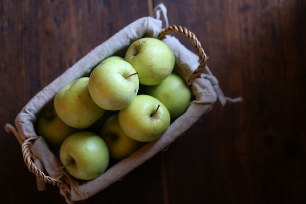 Pommes vertes en vue de dessus de panier en osier. Pommes fraîches biologiques du jardin.