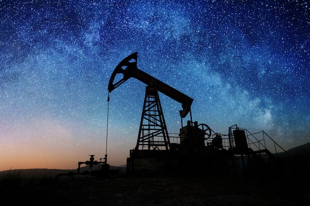 Pompe à huile sur le champ de pétrole dans la nuit