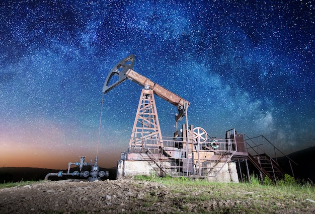 Pompe à huile sur le champ de pétrole dans la nuit