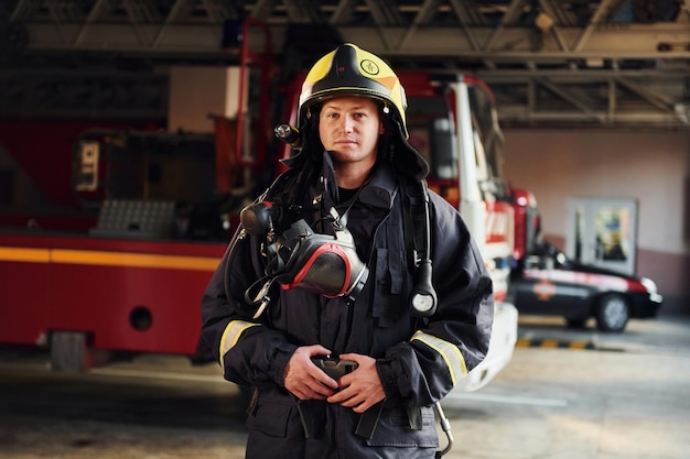 Pompier féminin dans l'uniforme protecteur se tenant près du camion