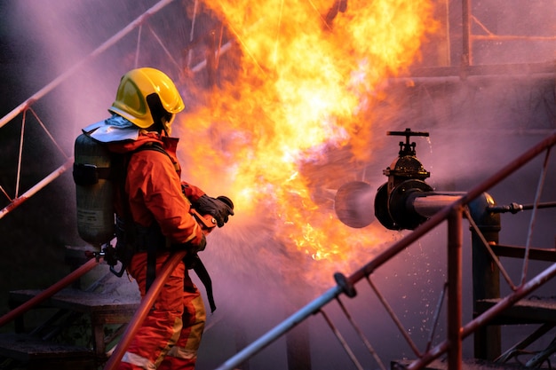 Pompier pulvérisant la flamme du pipeline la nuit