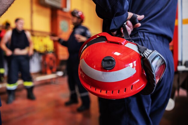 Pompier tenant un casque et écoutant un patron. Patron parle de tactique pour prendre soin du feu.