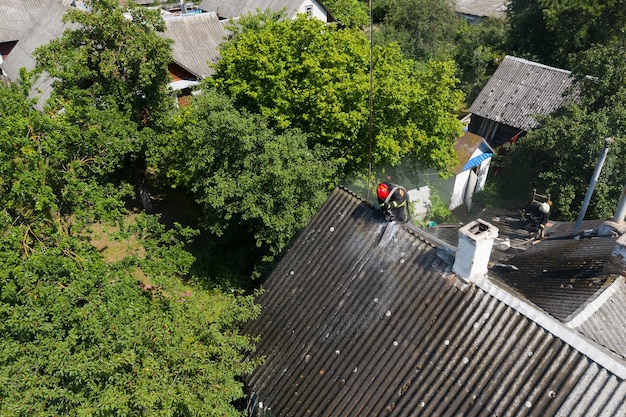 Le pompier sur le toit éteint le feu vue d'en haut