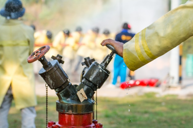 Pompiers floues utilisant de l'eau du tuyau pour lutter contre l'incendie