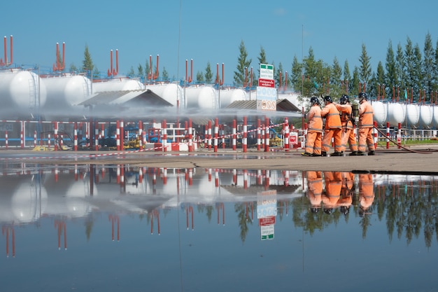 Pompiers en formation avec tuyau d'arrosage