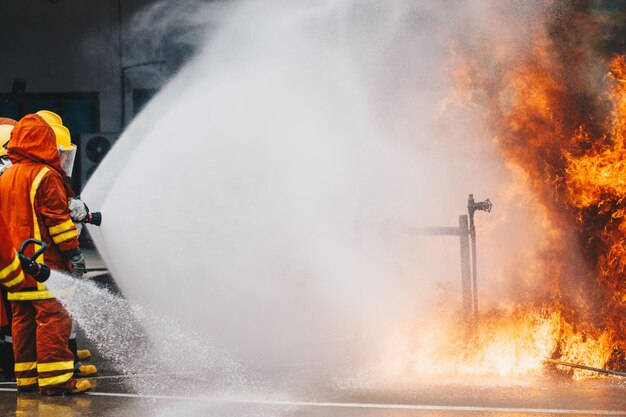 Photo des pompiers pulvérisent de l'eau sur le feu dans la rue.