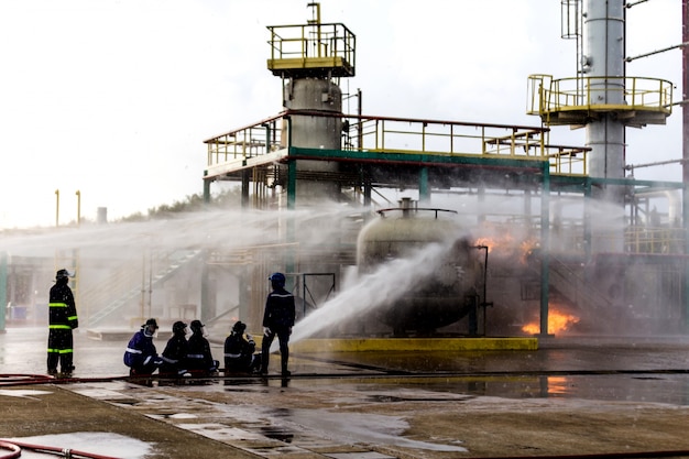 Pompiers utilisant l&#39;eau du tuyau pour la lutte contre l&#39;incendie à la formation des pompiers du groupe d&#39;assurance