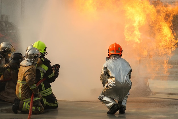 Pompiers utilisant un extincteur de type brouillard d'eau Twirl pour combattre avec la flamme du feu de l'huile pour contrôler le feu et ne pas se propager Concept de pompier et de sécurité industrielle