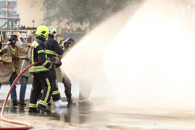 Pompiers utilisant un extincteur de type brouillard d'eau Twirl pour combattre avec la flamme du feu de l'huile pour contrôler le feu et ne pas se propager Concept de pompier et de sécurité industrielle