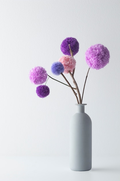 Pompons colorés dans un arrangement de vase