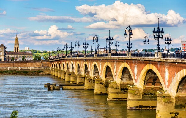 Photo un pont en arc sur la rivière contre un ciel nuageux.