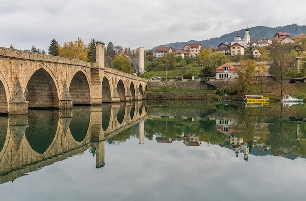 Photo pont en arche sur le lac par des bâtiments contre le ciel