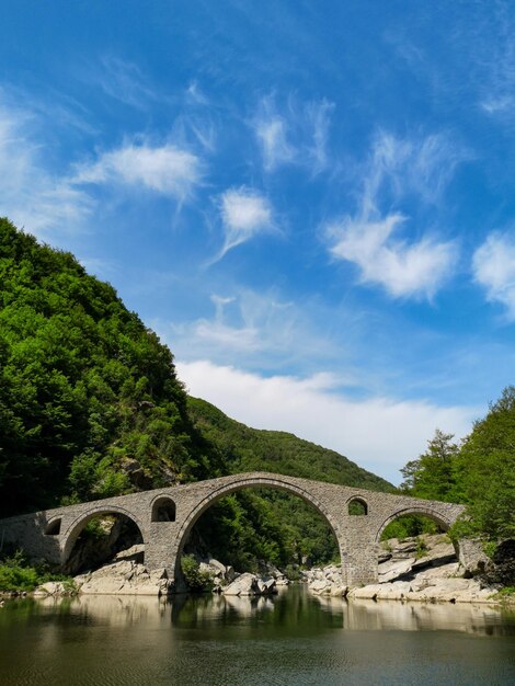 Photo pont en arche sur la rivière contre le ciel