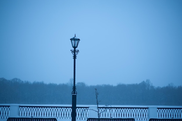 Pont automobile au-dessus d'une rivière enneigée dans la neige et le brouillard