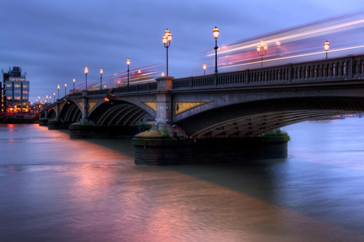 Photo le pont de battersea éclairé sur la rivière la nuit avec des bus en mouvement