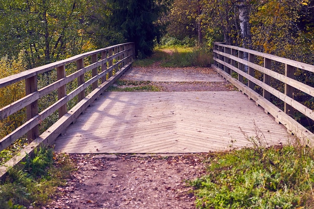 Pont en bois au-dessus d'une rivière de montagne dans la forêt d'automne