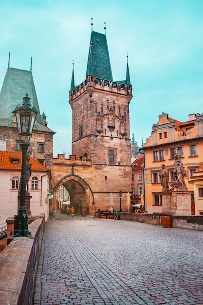 Le pont Charles avec tour et arche dans le paysage urbain tchèque de Prague avec pavé