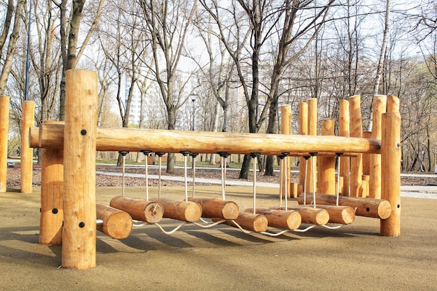 Pont de corde dans une aire de jeux en bois pour enfants modernes en plein air dans un parc public de la ville. Vie écologique