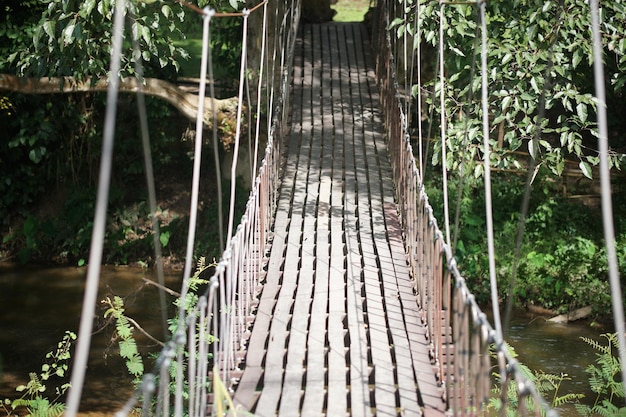 Photo pont de corde suspendu suspendu en bois dans le parc de jardin