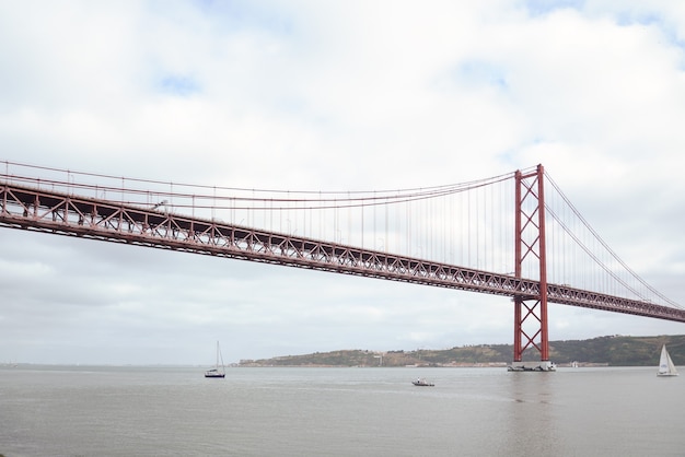 Pont du 25 avril sur le Tage sous un ciel nuageux à Lisbonne, Portugal