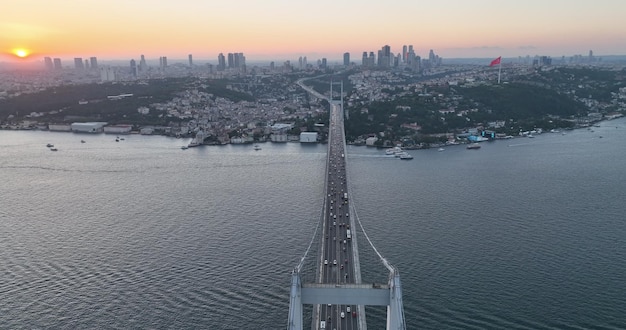 Le pont du Bosphore d'Istanbul et l'horizon de la ville en arrière-plan avec le drapeau turc au beau coucher de soleil