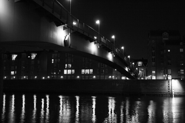 Pont éclairé sur la rivière contre le ciel la nuit