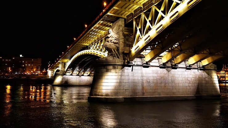 Photo pont éclairé sur la rivière dans la ville la nuit
