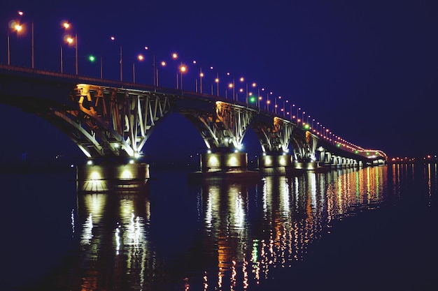 Le pont éclairé de Saratov sur la rivière la nuit
