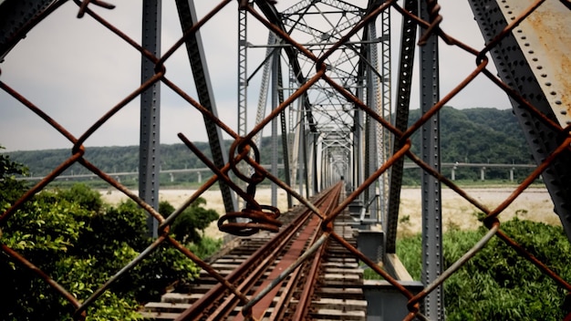 Photo pont ferroviaire vu à travers une clôture en chaîne