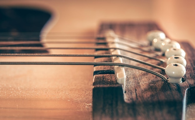 Photo pont de guitare acoustique et cordes en gros plan