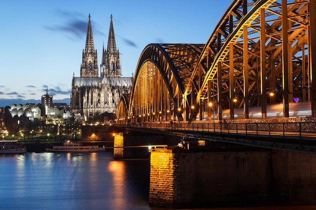 Pont Hohenzollern éclairé sur le Rhin par la cathédrale de Cologne au crépuscule