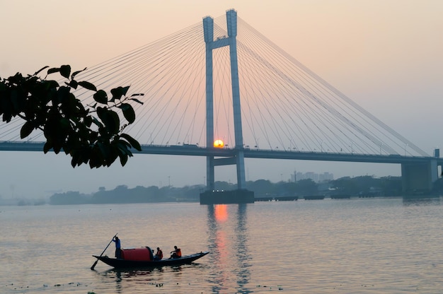 Photo le pont hooghly au coucher du soleil sur le fleuve gange à kolkata et à howrah