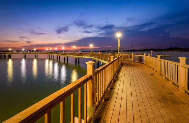 Photo pont illuminé sur la mer contre le ciel au coucher du soleil