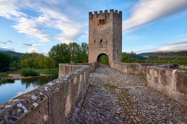 Pont médiéval au lever du soleil avec château en arrière-plan