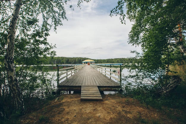 Pont de pêche au bord de la rivière. bateau débarquant sur le lac. eau et transport