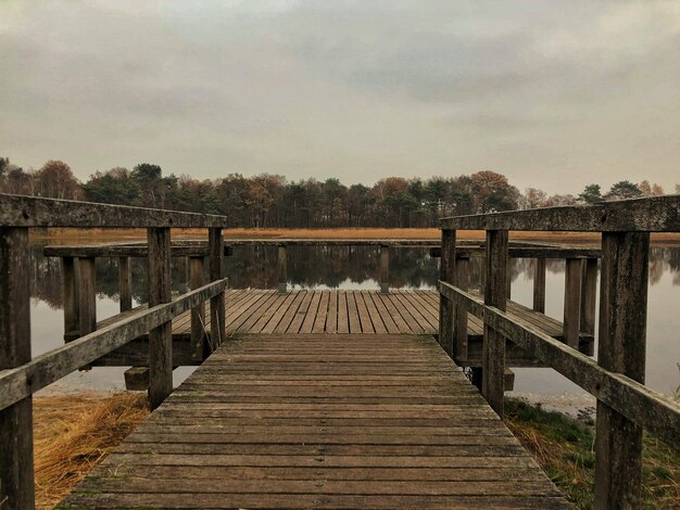 Pont piétonnier en bois sur la jetée contre le ciel