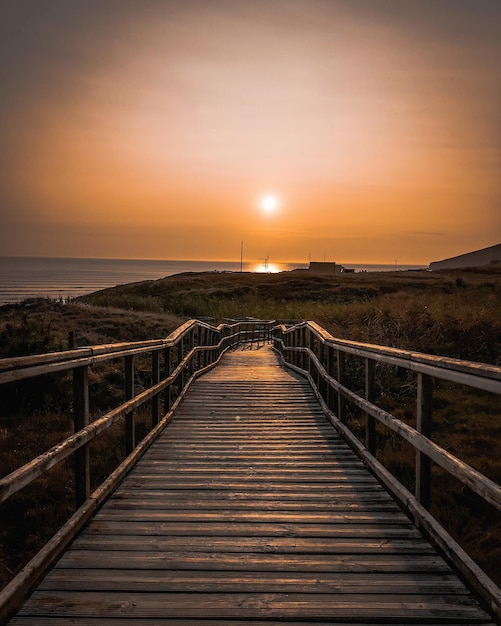 Pont piétonnier sur la mer contre le ciel au coucher du soleil