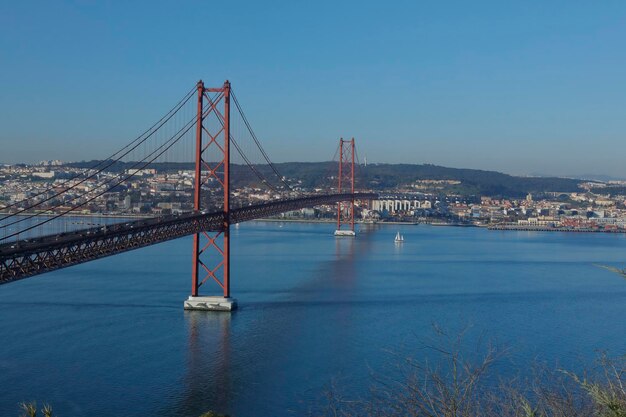 Photo le pont de la porte d'or sur la mer contre un ciel bleu clair au coucher du soleil