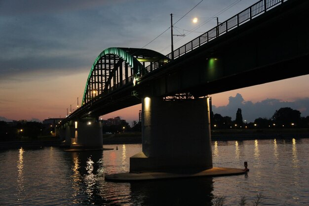 Photo pont sur la rivière contre le ciel au coucher du soleil