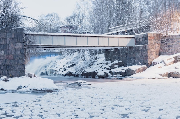 Pont sur une rivière gelée avec de la neige au sol et un pont en arrière-plan Helsinki Finlande