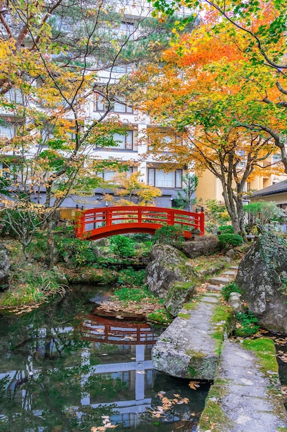 Photo pont rouge dans le parc vert japonais avec des feuilles de couleur d'automne, automne automne japonais