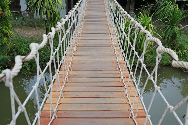 Photo pont suspendu en corde de bois pour promenade traversant la rivière.