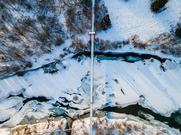 Pont suspendu suspendu au-dessus de la rivière San gelée dans les montagnes Bieszczady Pologne