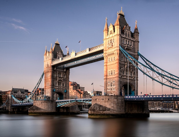 Le pont de la tour sur la rivière contre le coucher du soleil