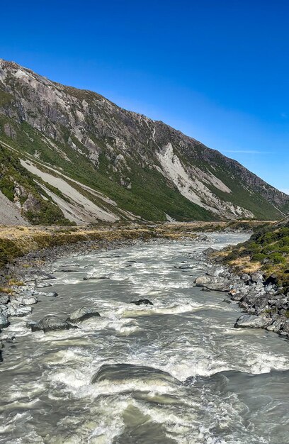 Le pont tournant sur la rivière Hooker inondée dans la vallée au pied du mont Aoraki Cook