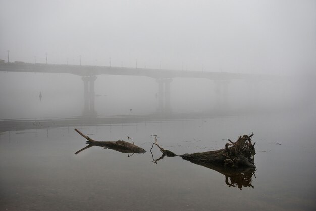 Pont à travers le fleuve Dniepr le matin brumeux avec un gros journal