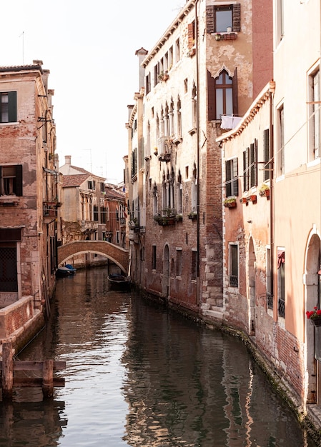 Pont typique fait de briques rouges sur le canal typique de Venise