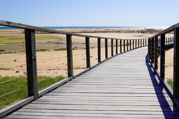 Ponton en bois passerelle d'accès à la mer sur la plage de sable horizon de l'océan atlantique à Jard sur Mer en france