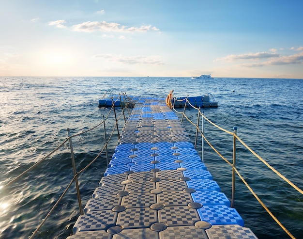 Ponton avec mains courantes dans la mer au coucher du soleil