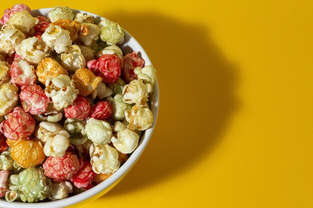 Pop-corn coloré fait maison sur table colorée avec une lumière à contraste élevé. Concept de collation